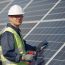 Engineer in a white helmet. Man near solar panel.